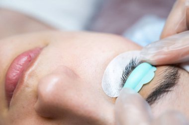 Sahip, müşteriye kirpikleri kaplamak için özel bir silindir takar