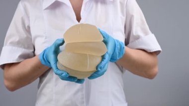 Plastik cerrah göğüs silikonu takıyor.