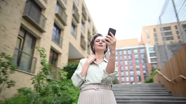 年长的高加索女人在户外智能手机上通过视频链接说话 视频旋转360度 — 图库视频影像