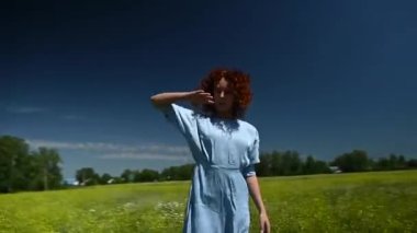 Mavi elbiseli beyaz bir kadın tarlada dans ediyor. Video 360 derece