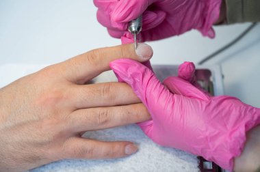 Usta, erkek müşteriye donanım manikürü yapıyor.