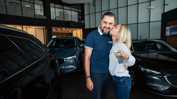 Feliz Casal Caucasiano Abraço Mulher Segurando Novas Chaves Carro Showroom — Fotografia de Stock