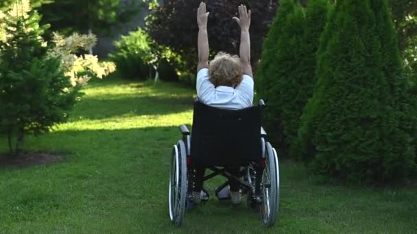 Äldre Kaukasiska Kvinna Som Motionerar Medan Hon Sitter Rullstol Utomhus — Stockvideo