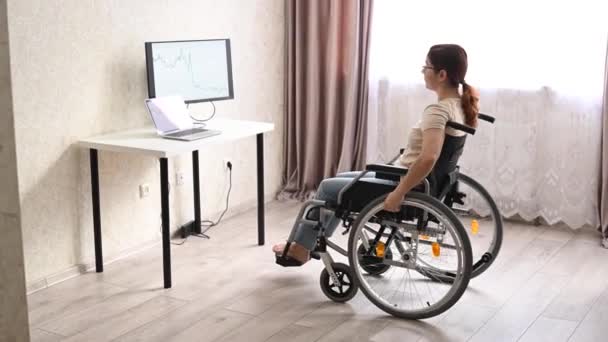 Белая Женщина Инвалидном Кресле Подъезжает Своему Столу Начинает Печатать Ноутбуком — стоковое видео