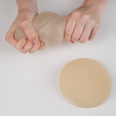 Beyaz bir kadın göğüs implantının gücünü test ediyor.