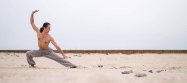 Kafkasyalı, uzun saçlı, dışarıda qigong antrenmanı yapan bir adam.