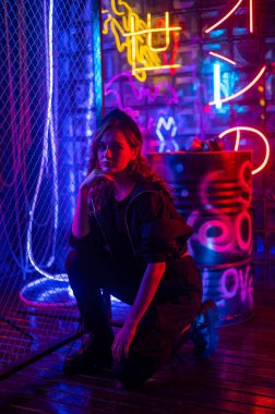 Beyaz kadın neon stüdyoda poz veriyor.