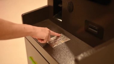 Yüzsüz kadın ATM 'de banka kartı şifresini çeviriyor.