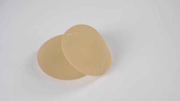 Twee Siliconen Implantaten Draaien Een Witte Achtergrond — Stockvideo