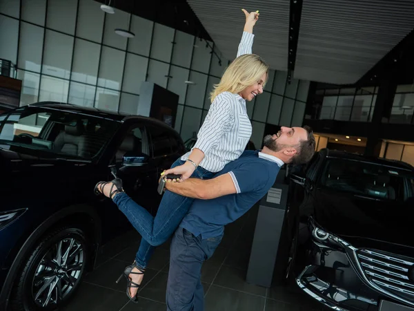 Feliz Casal Caucasiano Abraçando Enquanto Compra Carro Novo Uma Concessionária — Fotografia de Stock