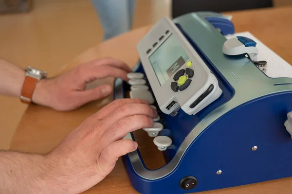 Blind man using braille typewriter