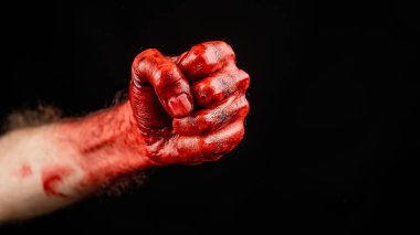 Siyah arka planda kanlı erkek yumruğu