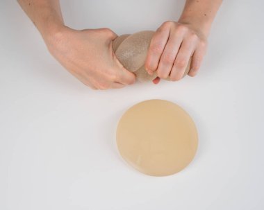Beyaz bir kadın göğüs implantının gücünü test ediyor.