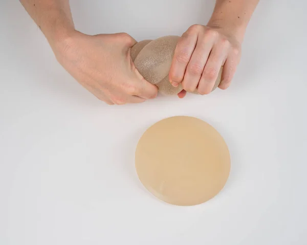 Caucasian woman testing the strength of a breast implant