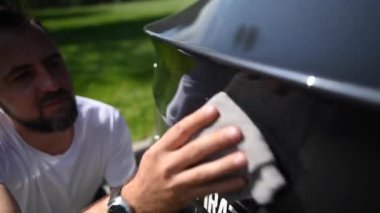 Beyaz adam araba tamponuna Tesla rozetini sildi.