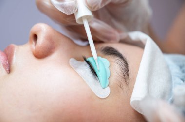 Kirpik boyama ve kaplama prosedüründen geçen genç bir kadın.