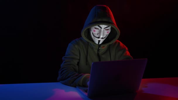 2022年6月5日ロシア ノヴォシビルスク フード内の匿名は 赤青の光で暗闇の中でノートパソコンに入力されています — ストック動画