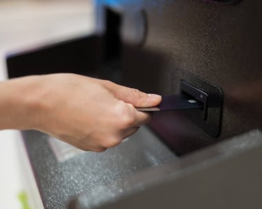 Meçhul kadın ATM 'ye banka kartı yerleştiriyor.