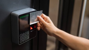 Bir kadın kapıyı plastik kartla açıyor. Modern anahtarsız giriş kilidi