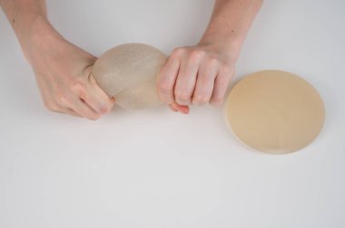 Beyaz bir kadın göğüs implantının gücünü test ediyor.