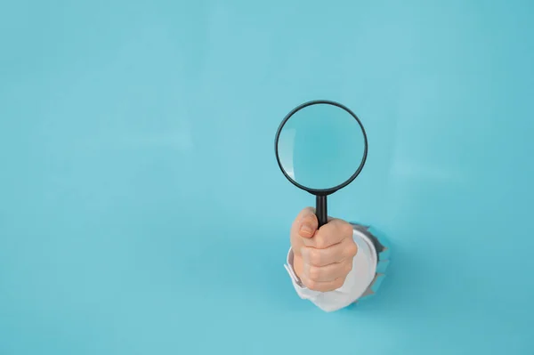 Eine Frauenhand Die Aus Einem Loch Einem Papierblauen Hintergrund Ragt — Stockfoto