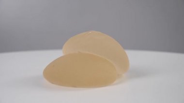 Beyaz bir arka planda iki silikon implant dönüyor.