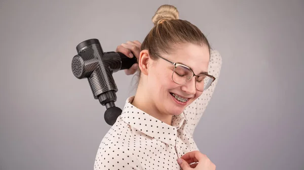 Usmívající Žena Rovnátky Používá Masážní Pistole Pro Její Záda — Stock fotografie