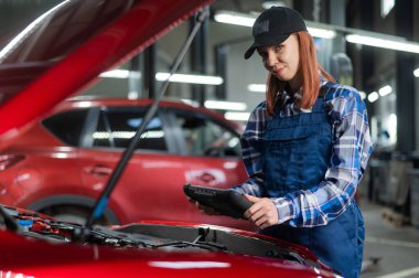 Kafkas kadın oto tamircisi hataları teşhis etmek için özel bir bilgisayar kullanıyor.