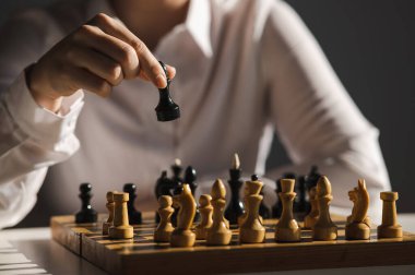 Beyaz tişörtlü, satranç oynayan yüzü olmayan beyaz kadın.
