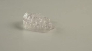Şeffaf bir plastik hizalayıcı beyaz bir arkaplanda dönüyor