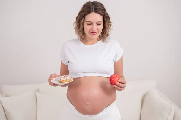 Těhotná Žena Drží Červené Jablko Koblihu Volba Jídla — Stock fotografie