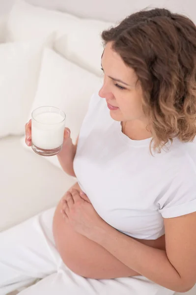 Uma Mulher Grávida Senta Sofá Branco Bebe Leite — Fotografia de Stock