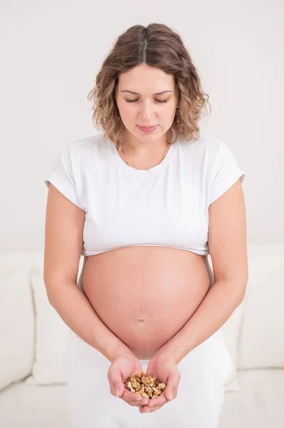 Беременная Женщина Держит Горсть Грецких Орехов — стоковое фото