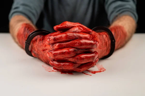 白いテーブルの上に血のついた手錠をかけられた男の肖像画 — ストック写真