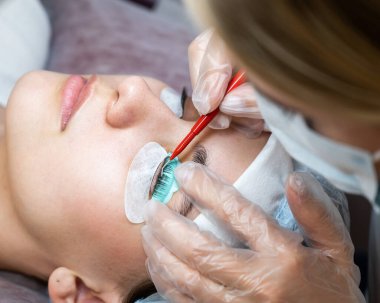 Usta kirpikleri kaplamak için çok fonksiyonlu bir araç kullanır