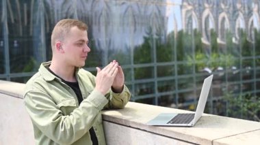 Beyaz adam dizüstü bilgisayardaki video bağlantısıyla işaret diliyle iletişim kuruyor.
