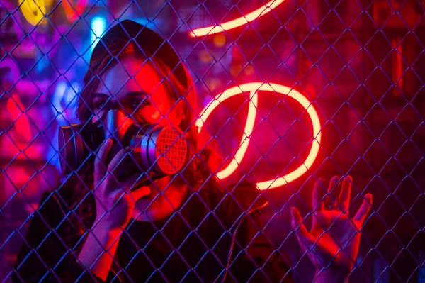 Neon Bir Stüdyoda Çitin Arkasında Gaz Maskeli Beyaz Bir Kadın — Stok fotoğraf