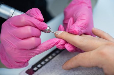 Usta, erkek müşteriye donanım manikürü yapıyor.