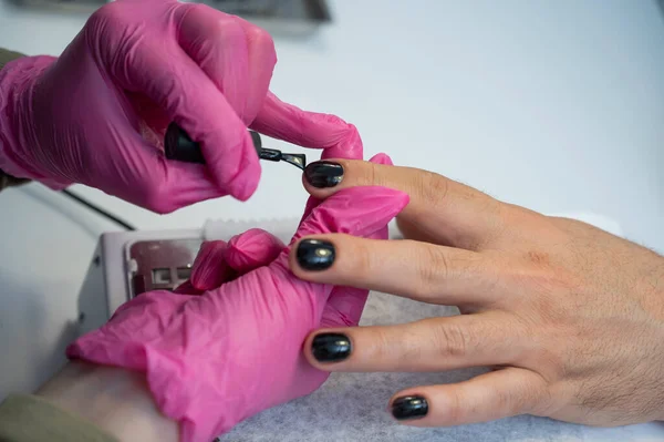 Een Man Een Manicure Procedure Schildert Zijn Nagels Zwart Een — Stockfoto