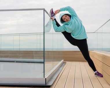 Eşofmanlı beyaz kadın açık havada esniyor.