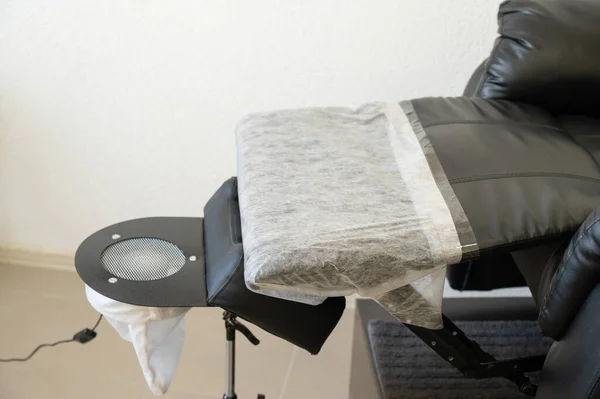 Black pedicure chair with dust vacuum cleaner in beauty salon