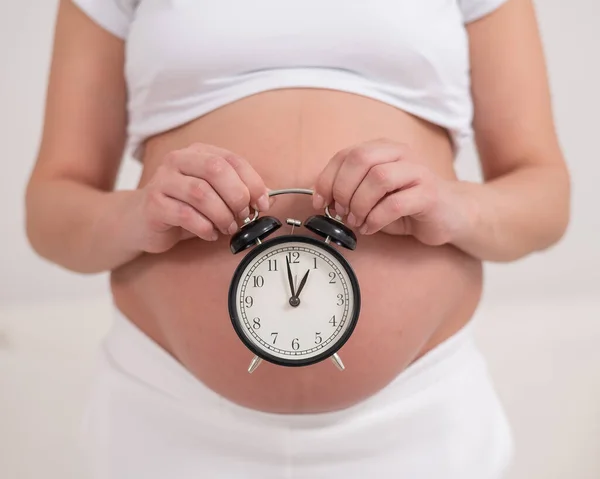 Egy Terhes Meztelen Pocakkal Egy Ébresztőórát Tart Születés Tervezett Időpontja — Stock Fotó