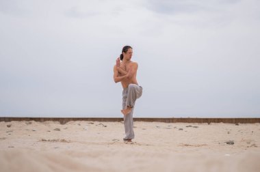 Beyaz adam dışarıda dövüş sanatları yapıyor. denge ve meditasyon