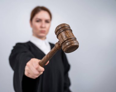 Mahkeme tokmağı tutan, bornozlu kadın yargıç.