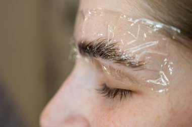 Kalıcı stil ve kaş boyama prosedürü üzerine beyaz kadın.