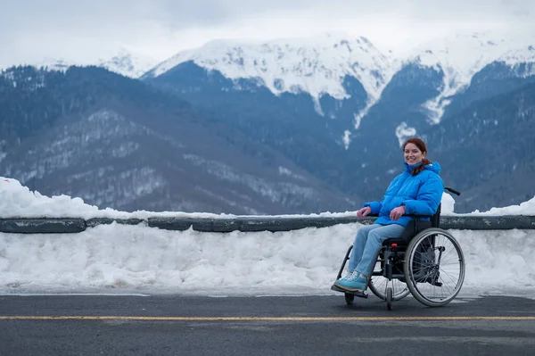Μια Ευτυχισμένη Γυναίκα Ντυμένη Μπλε Παλτό Κάθεται Μια Αναπηρική Καρέκλα — Φωτογραφία Αρχείου