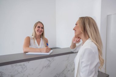 Güzellik salonunun yöneticisi müşteriyi not defterine yazmış.