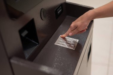 Yüzsüz kadın ATM 'de banka kartı şifresini çeviriyor.