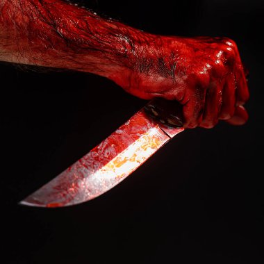 Siyah arka planda kanlı eli olan bir adam bıçak tutuyor.