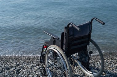 Kayalık bir sahilde boş bir tekerlekli sandalye.